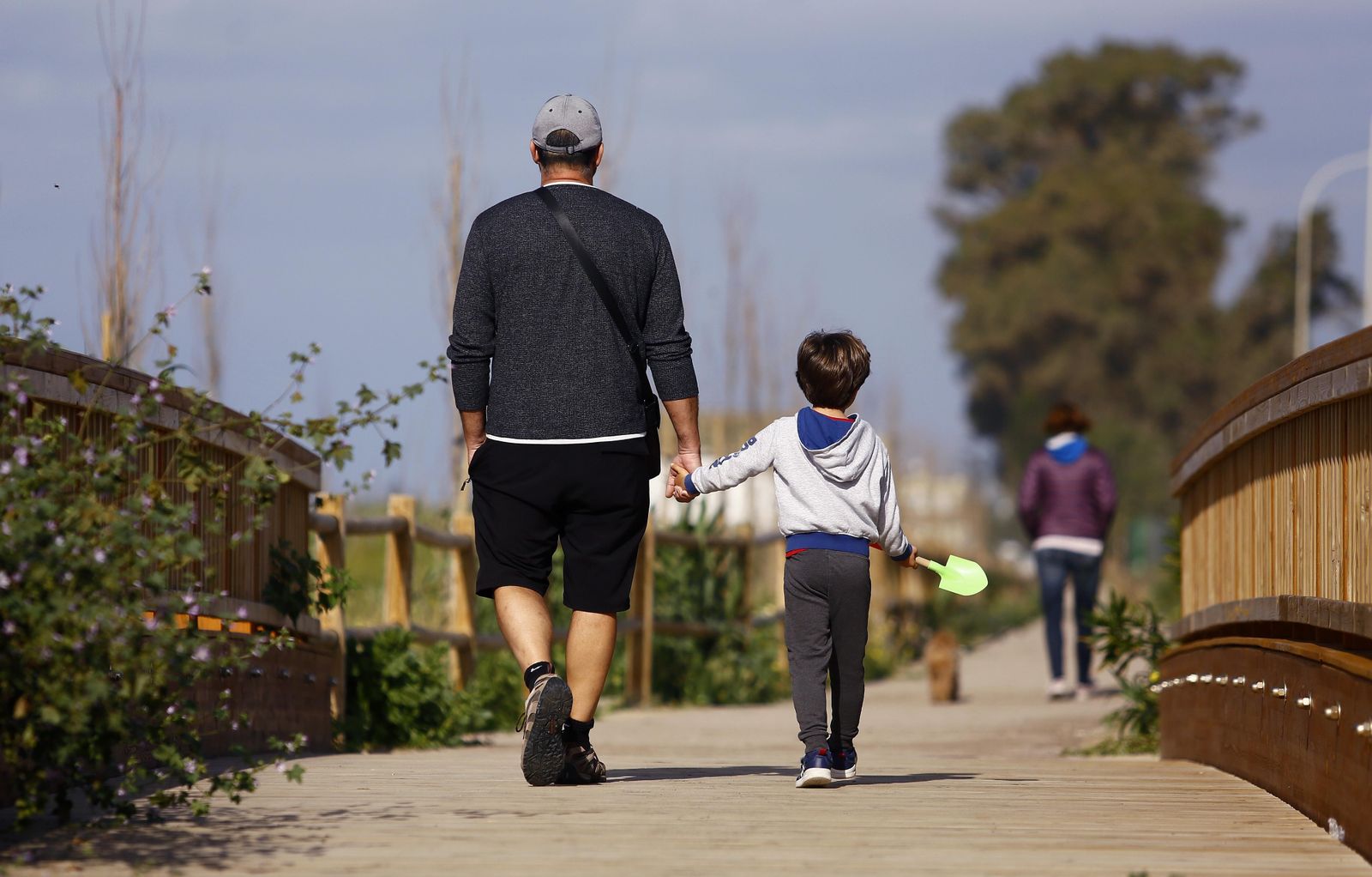 Un niño pasea junto a su padre en Málaga.