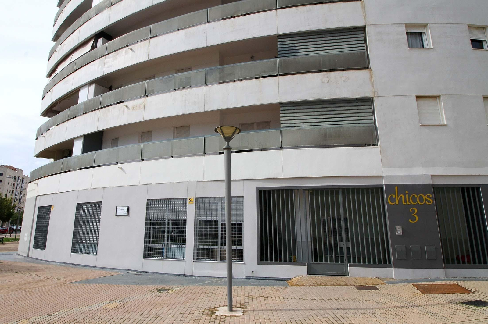 Fachada del centro infantil Chicos 3, con el patio de juegos tras los barrotes.