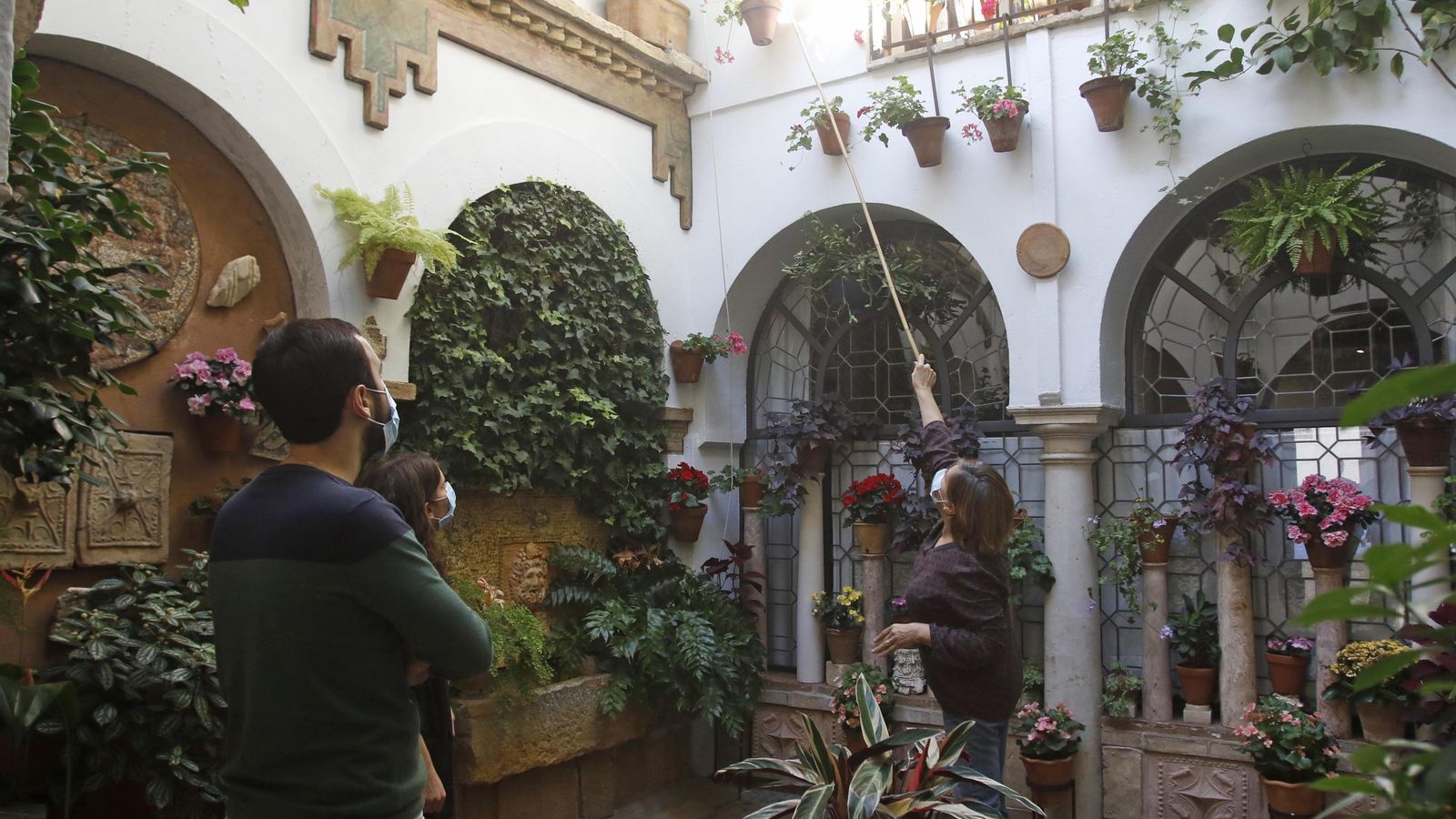 Una pareja observa el sistema de riego de las macetas colgadas en los patios.