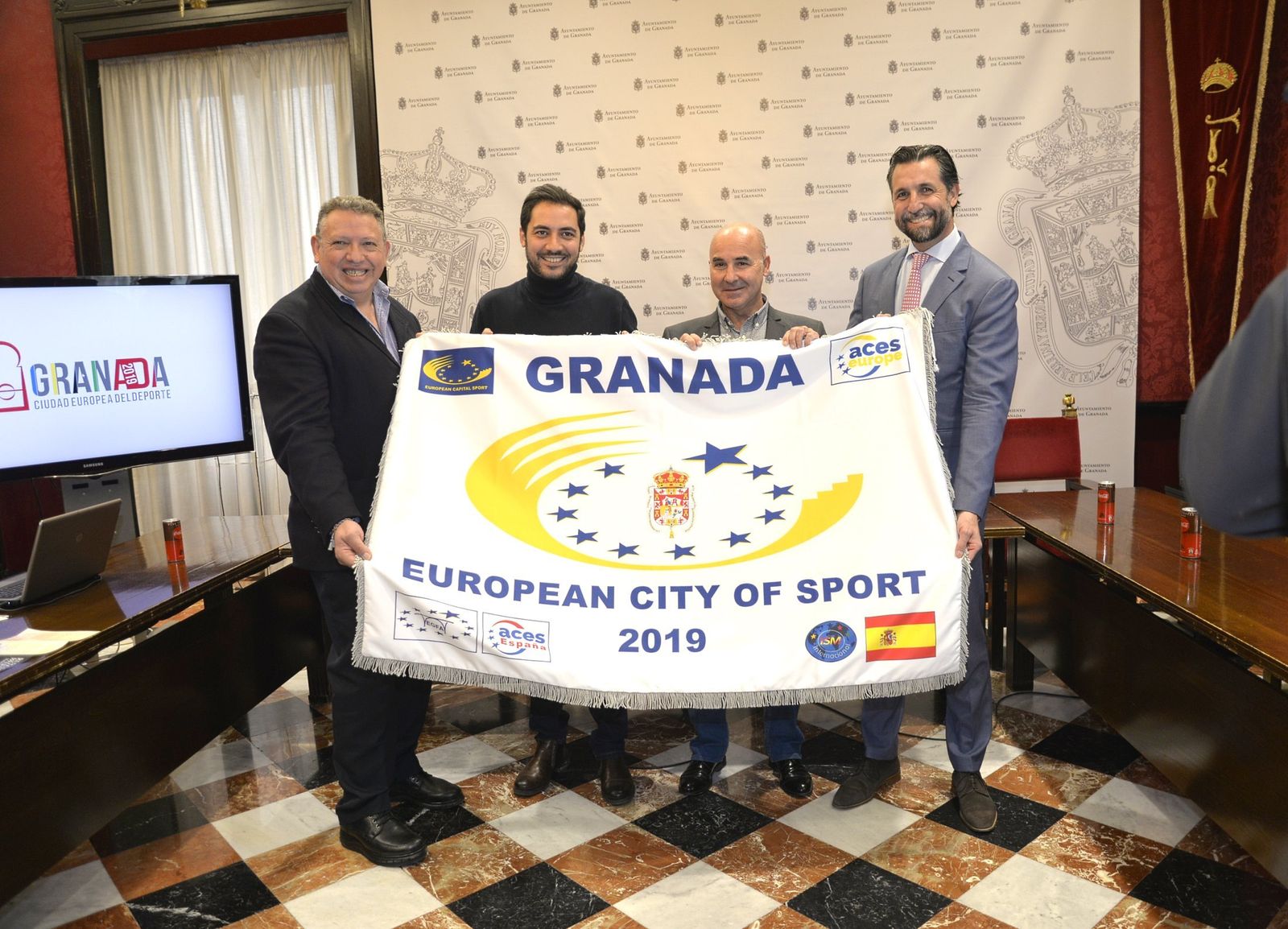 El concejal de Deportes, Eduardo Castillo, junto a Juan Carlos Rodríguez y Carlos Hernández, con la bandera de Ciudad Europea del Deporte