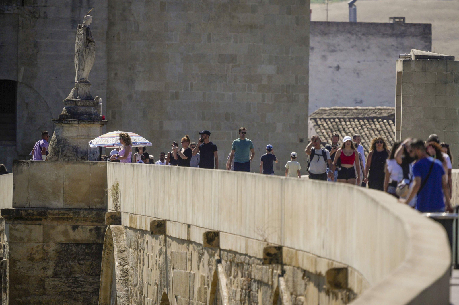 Turistas caminan bajo el sol en el Puente Romano de Córdoba. Turistas caminan bajo el sol en el Puente Romano de Córdoba.