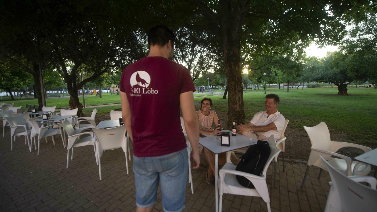 Juan Pintor atiende a dos clientes en su terraza. Juan Pintor atiende a dos clientes en su terraza.