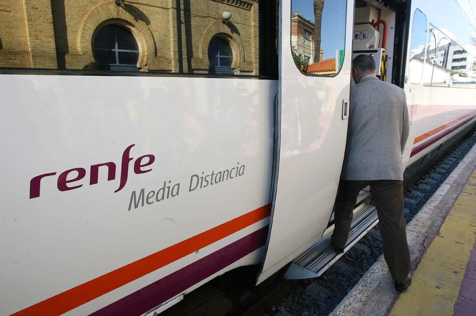 Un hombre sube a un tren de Media Distancia.