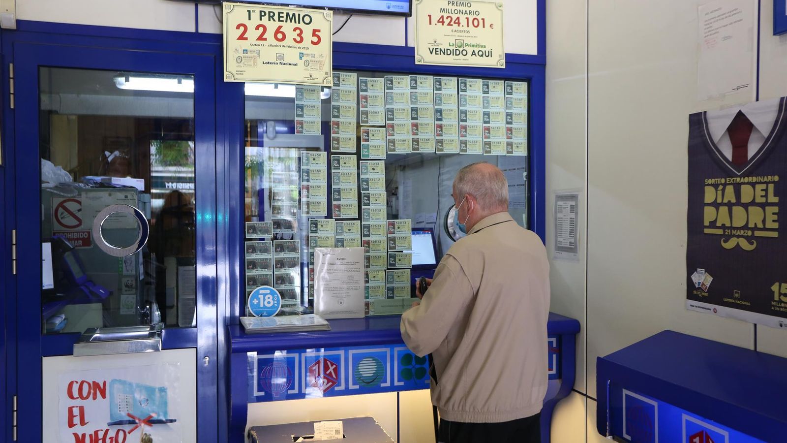 Un hombre compra lotería en una Administración de Lotería. Imagen de archivo