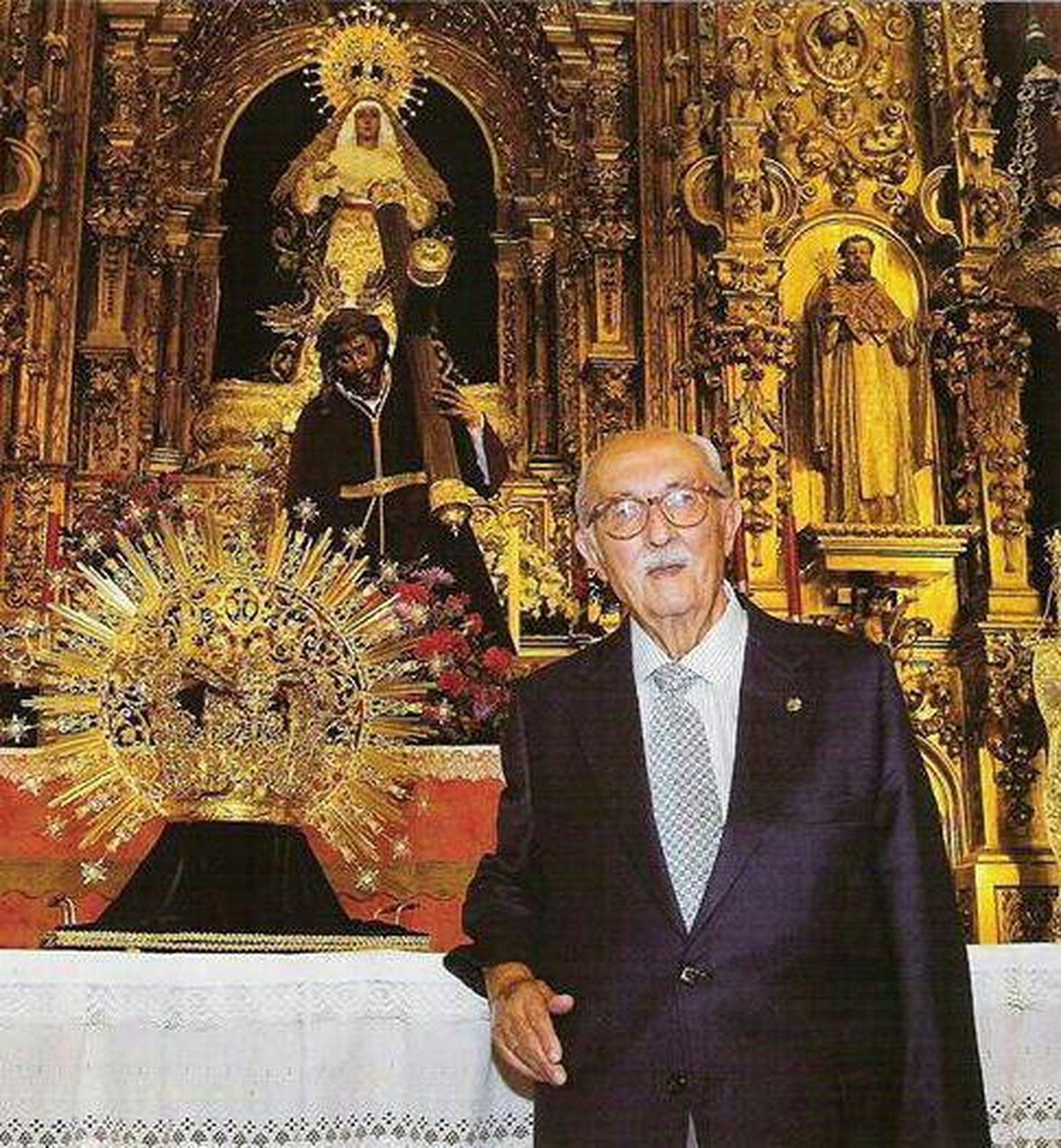 Una fotografía de Vicente Acosta posando junto a la corona de la Esperanza de Triana