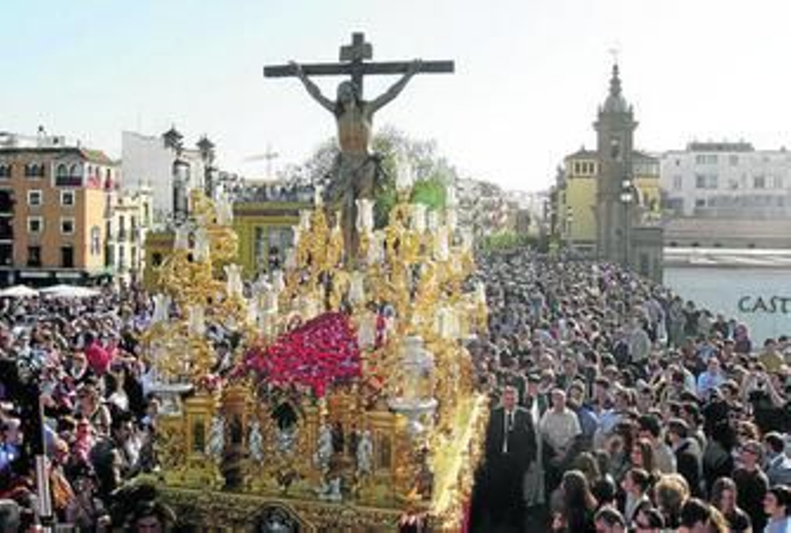 El Cristo de la Expiración discurre por un abarrotado puente de Triana en la tarde del Viernes Santo.