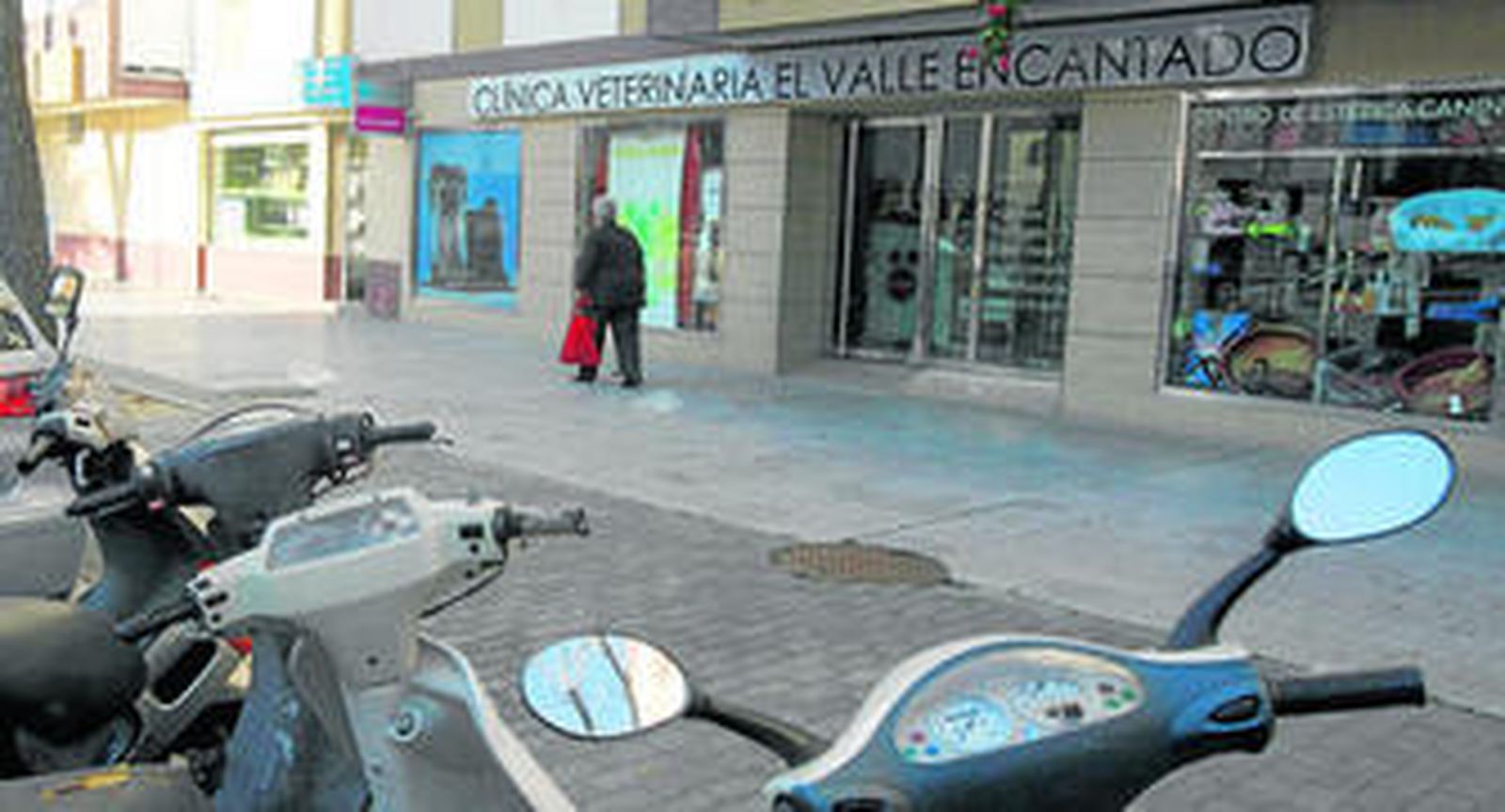 Una mujer pasa frente a  la clinica veterinaria establecida en los bajos de la avenida Guadalquivir, ayer por la mañana.