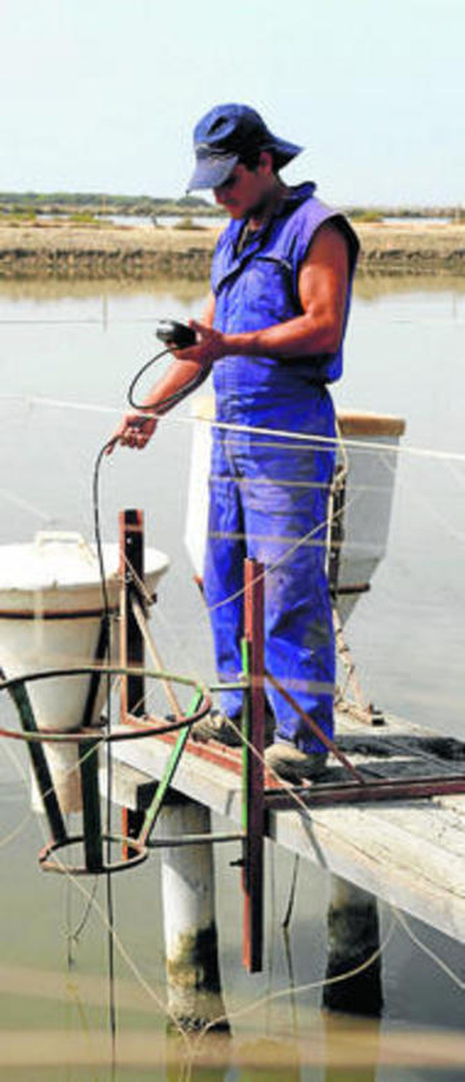 Un operario realiza mediciones en las instalaciones de una empresa acuícola.
