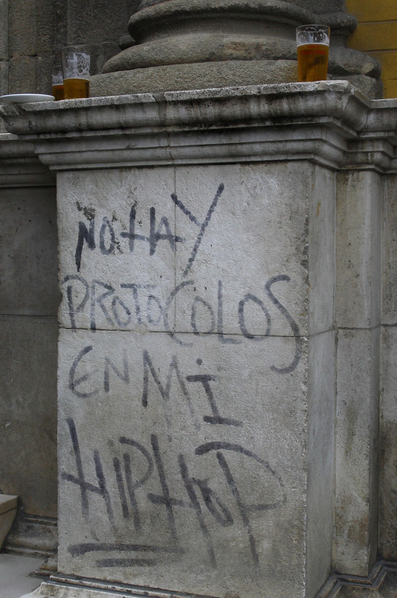 Cervezas y pintadas en el basamento de la portada del Archivo de Protocolos