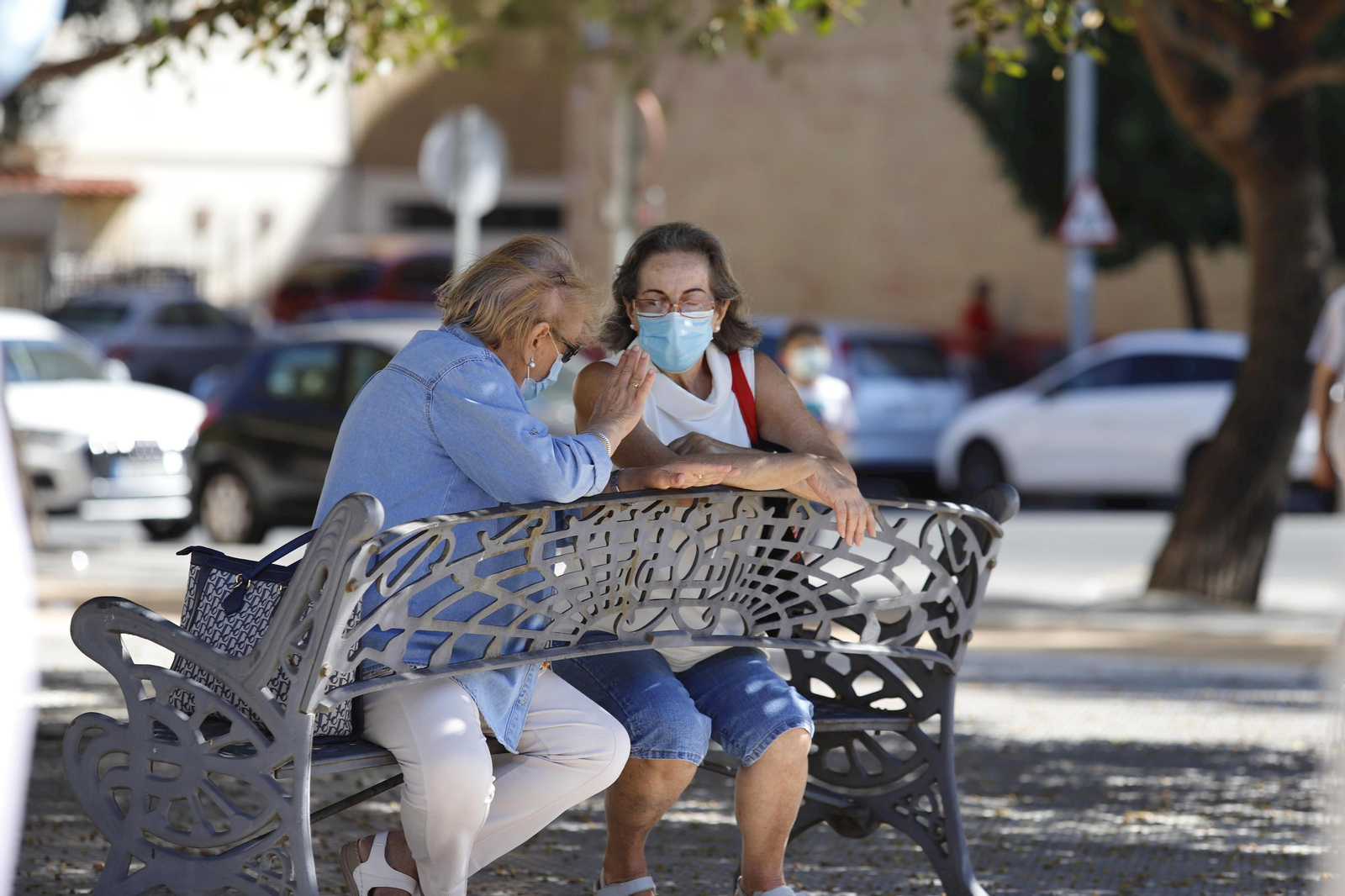 Dos mujeres conversan en un banco con sus mascarillas de protección contra la Covid-19.