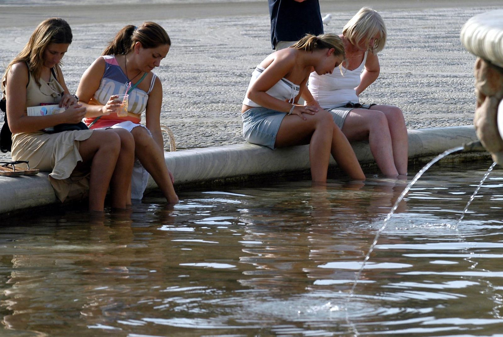 Turistas se refrescan en una fuente de la capital.