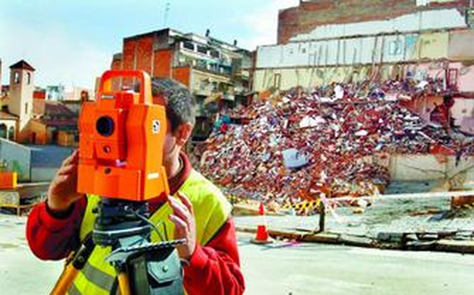 Un operario hace mediciones en una zona de viviendas derruidas del barrio del Carmel por las obras del Metro.