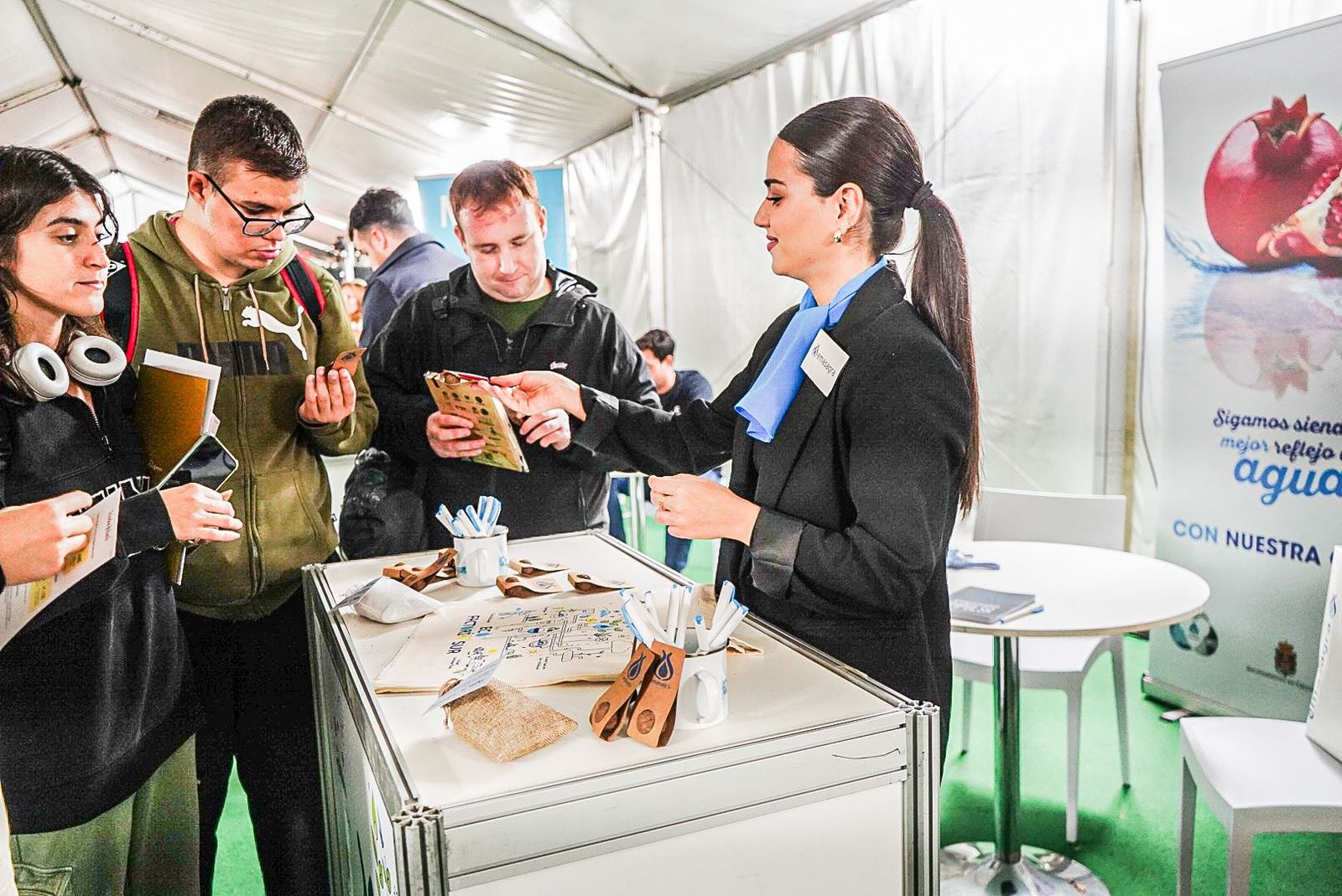 Visitantes recogen información del stand de Emasagra en la Feria de la Sostenibilidad de Granada