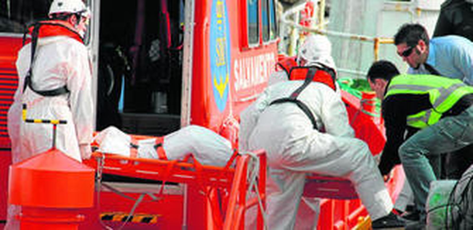 Efectivos de Salvamento Marítimo y la Guardia Civil bajan a puerto uno de los cadáveres de los marineros, ayer.