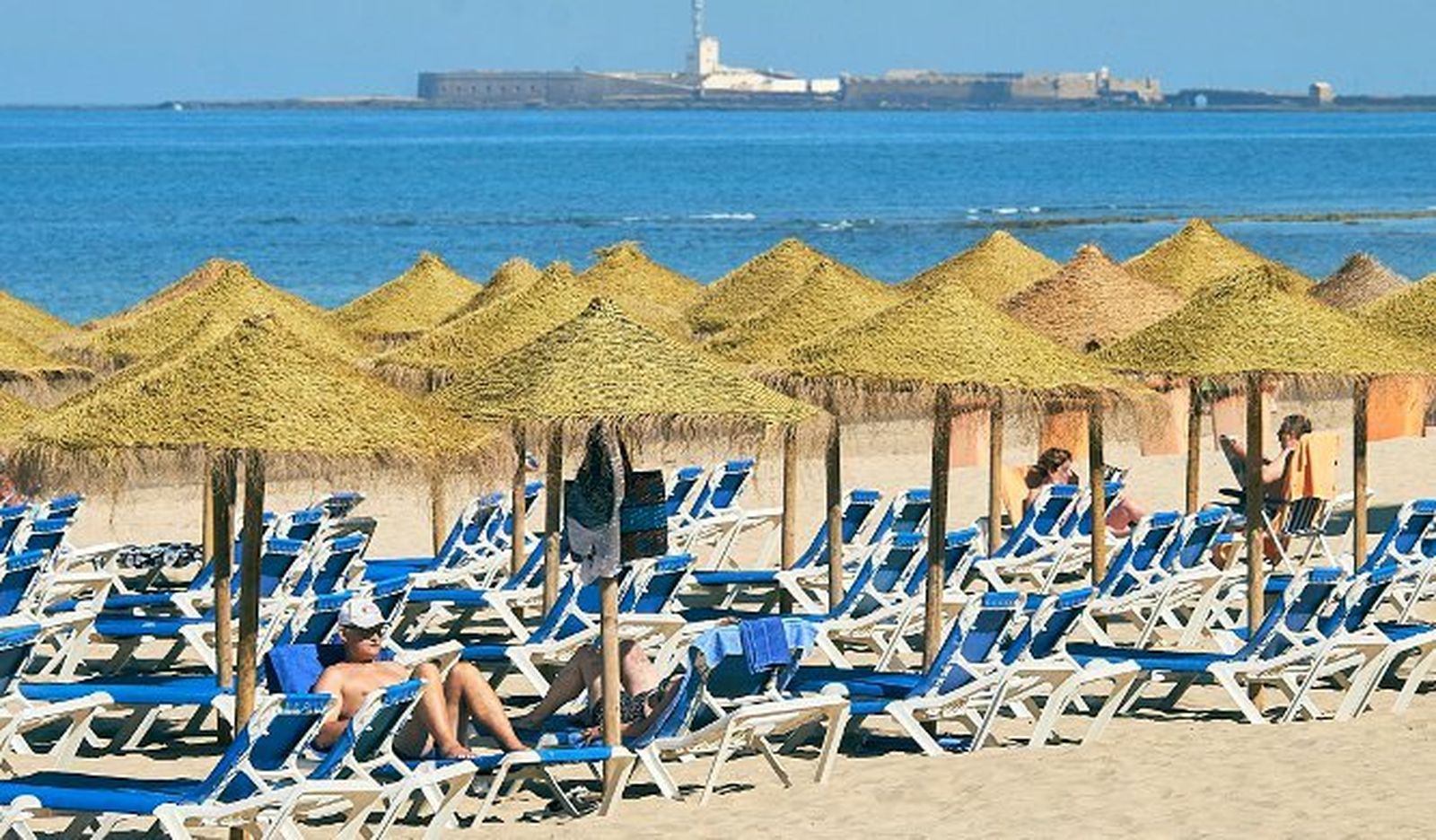 Unos turistas descansan en la playa Victoria.