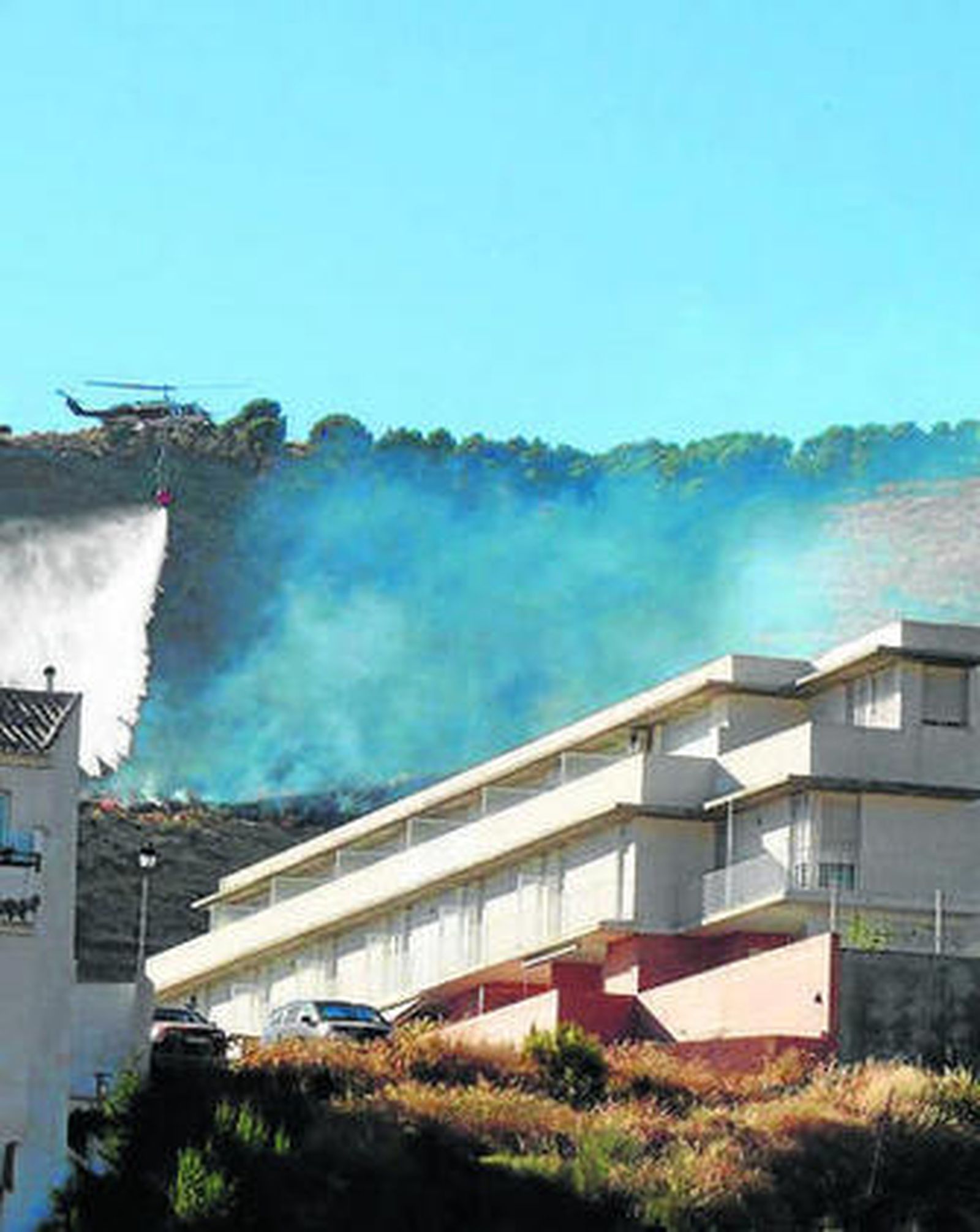 Secuencia de una de las descargas de los helicópteros del Infoca sobre la zona afectada por el fuego.