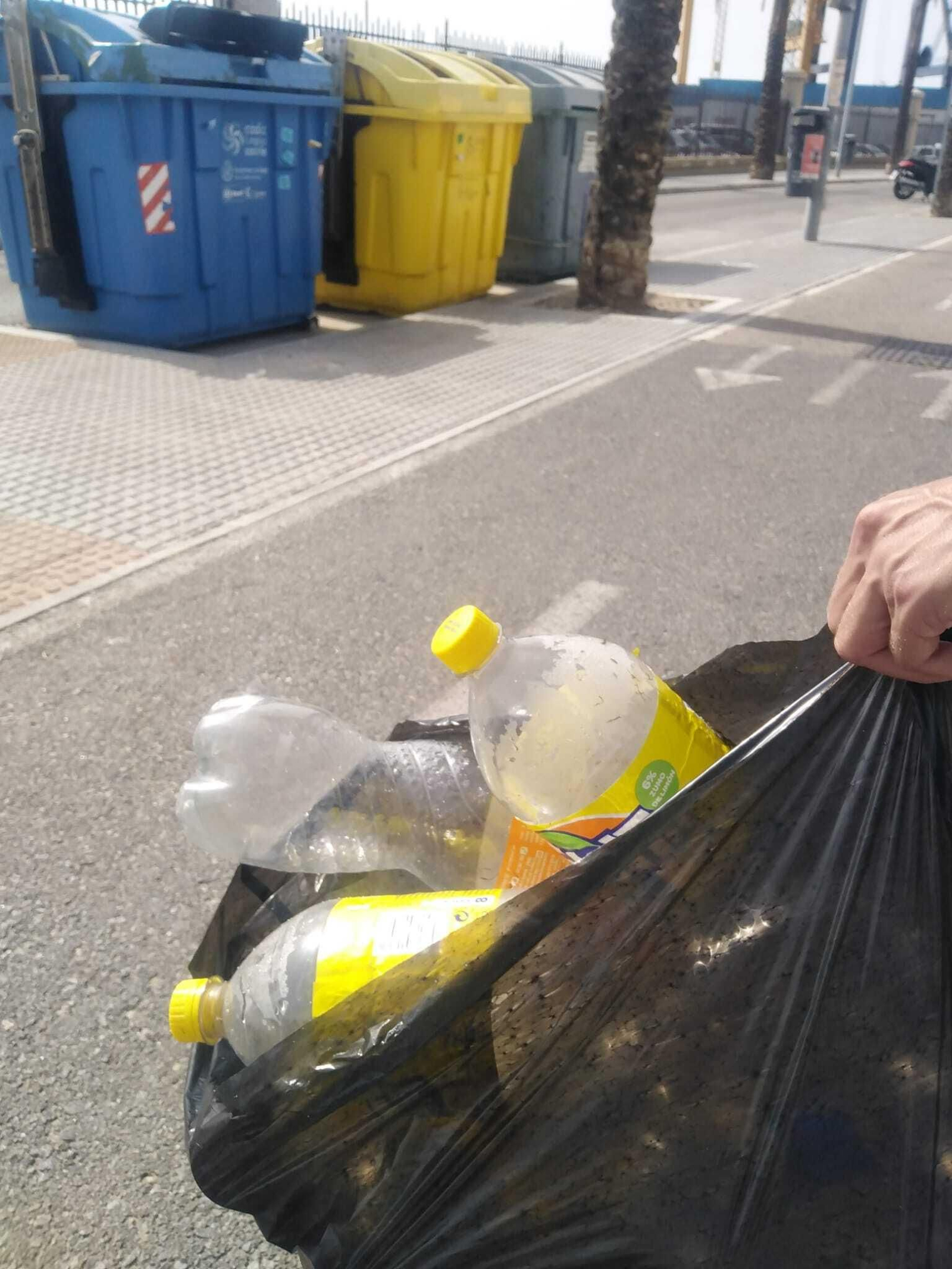 Uno de los usuarios, momentos antes de llevar parte de las botellas al contenedor de reciclado.