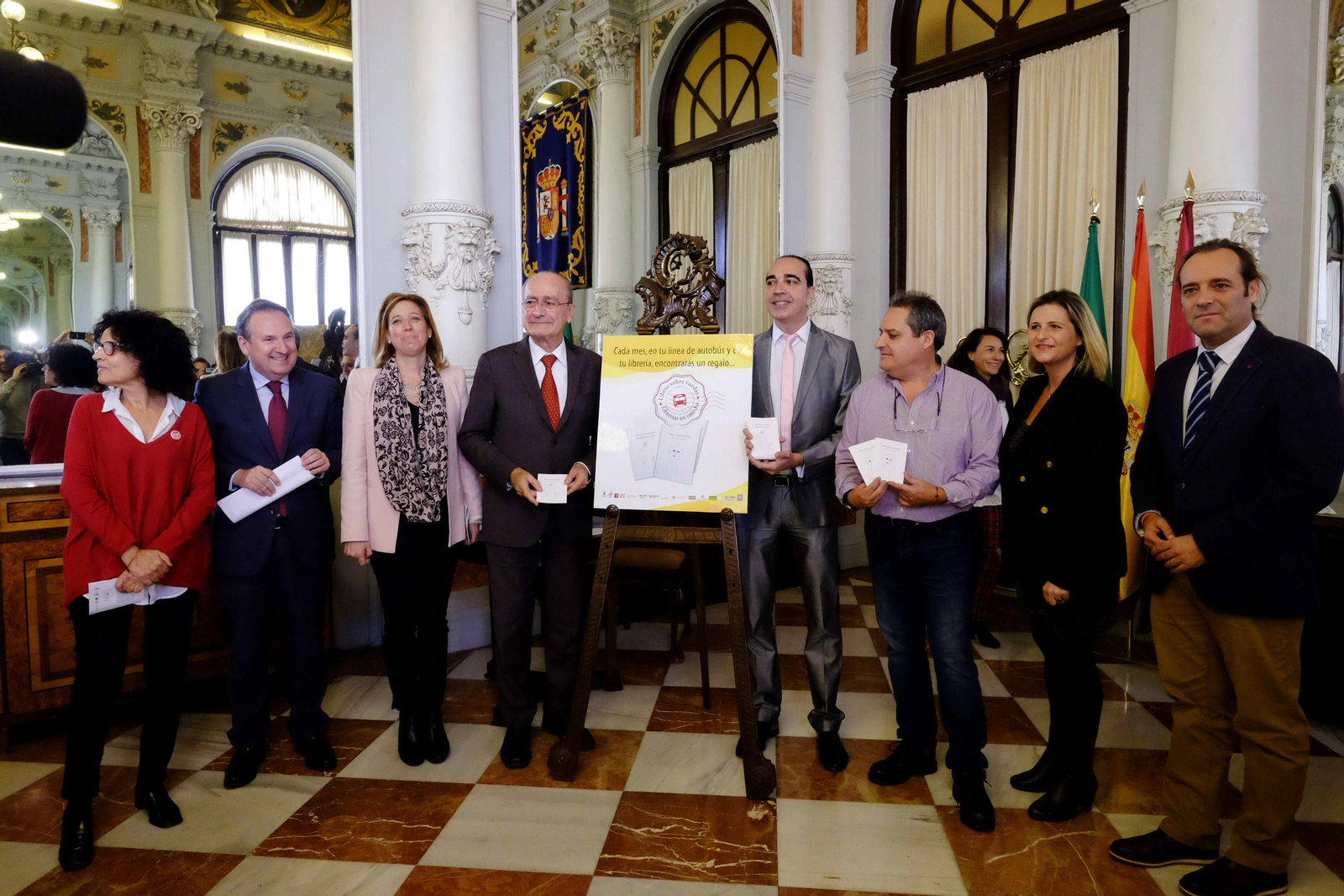 Responsables de la propuesta posando junto al cartel de la campaña.