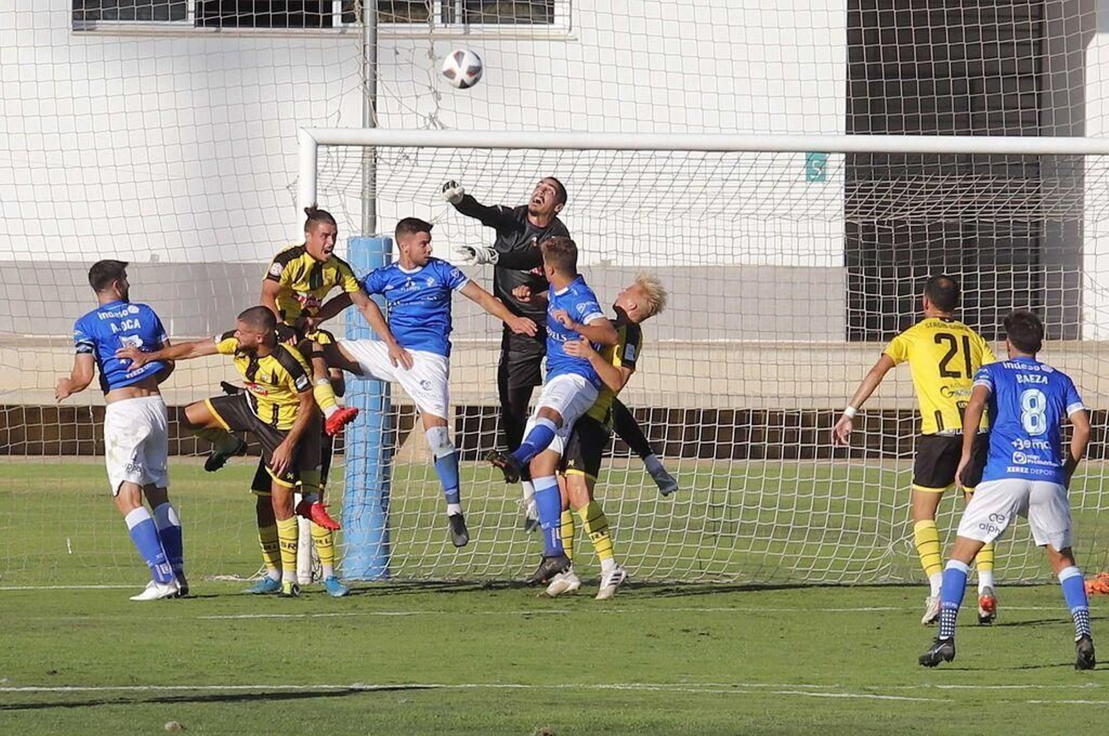 Simeone salta agarrado por un central mientras Robador intenta despejar el balón.