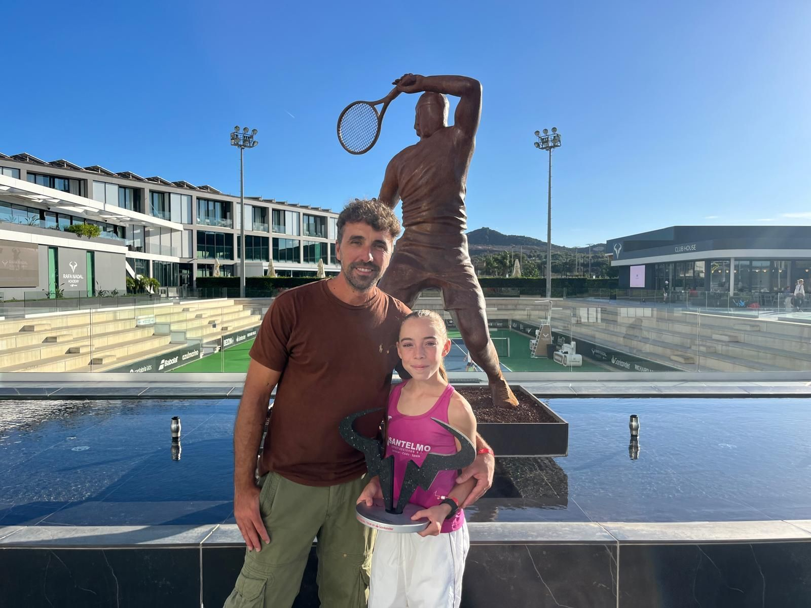 Paula Cuevas posa junto a su padre Javier con el trofeo obtenido en la Academia de Rafa Nadal.