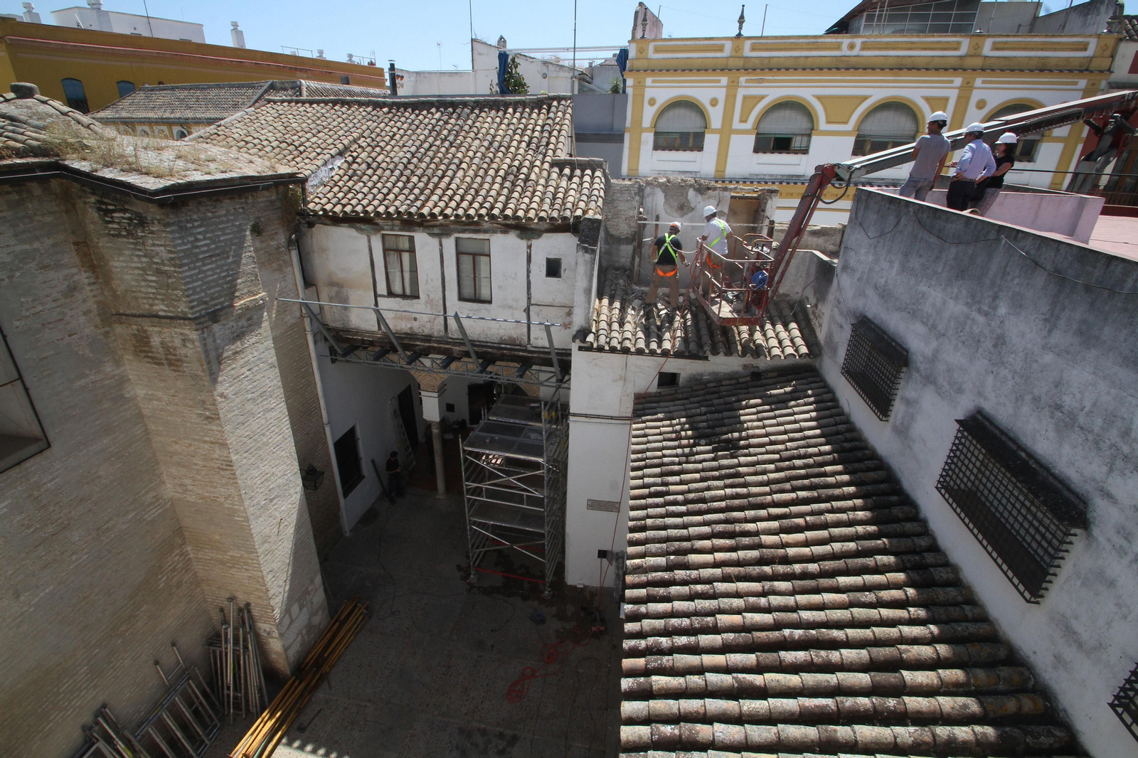 Andamios, grúas y operarios trabajando ayer en el compás de entrada y varias cubiertas de Santa Inés.