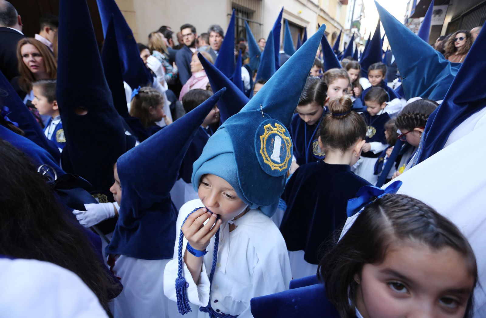 Un joven nazareno de la hermandad de la Flagelación tomar fuerzas comiendo un bocadillo tras algunas horas de procesión.