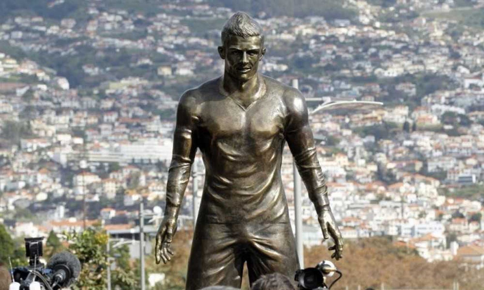 Estatua de un futbolista con paisaje al fondo.