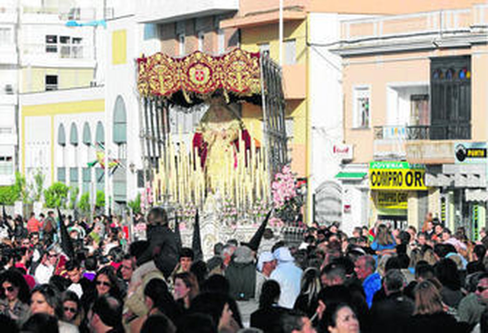 La Virgen del Rosario inicia su camino hacia el centro de Huelva en una tarde luminosa, a pesar del susto del chaparrón.