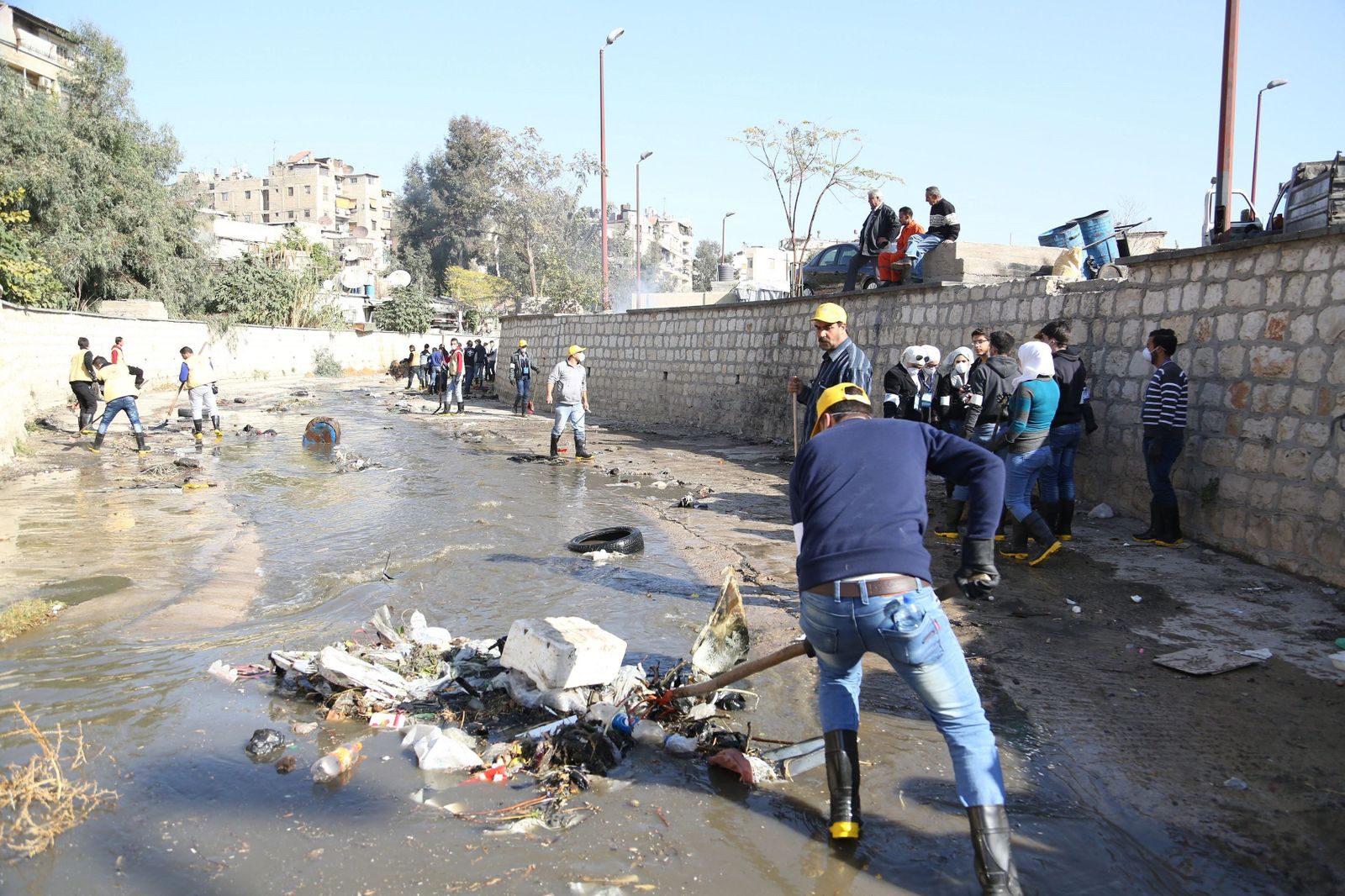 Varias personas realizan tareas de limpieza en un canal, ayer en Damasco.