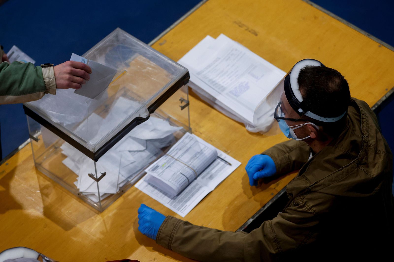 Un votante deposita su papeleta en una urna.