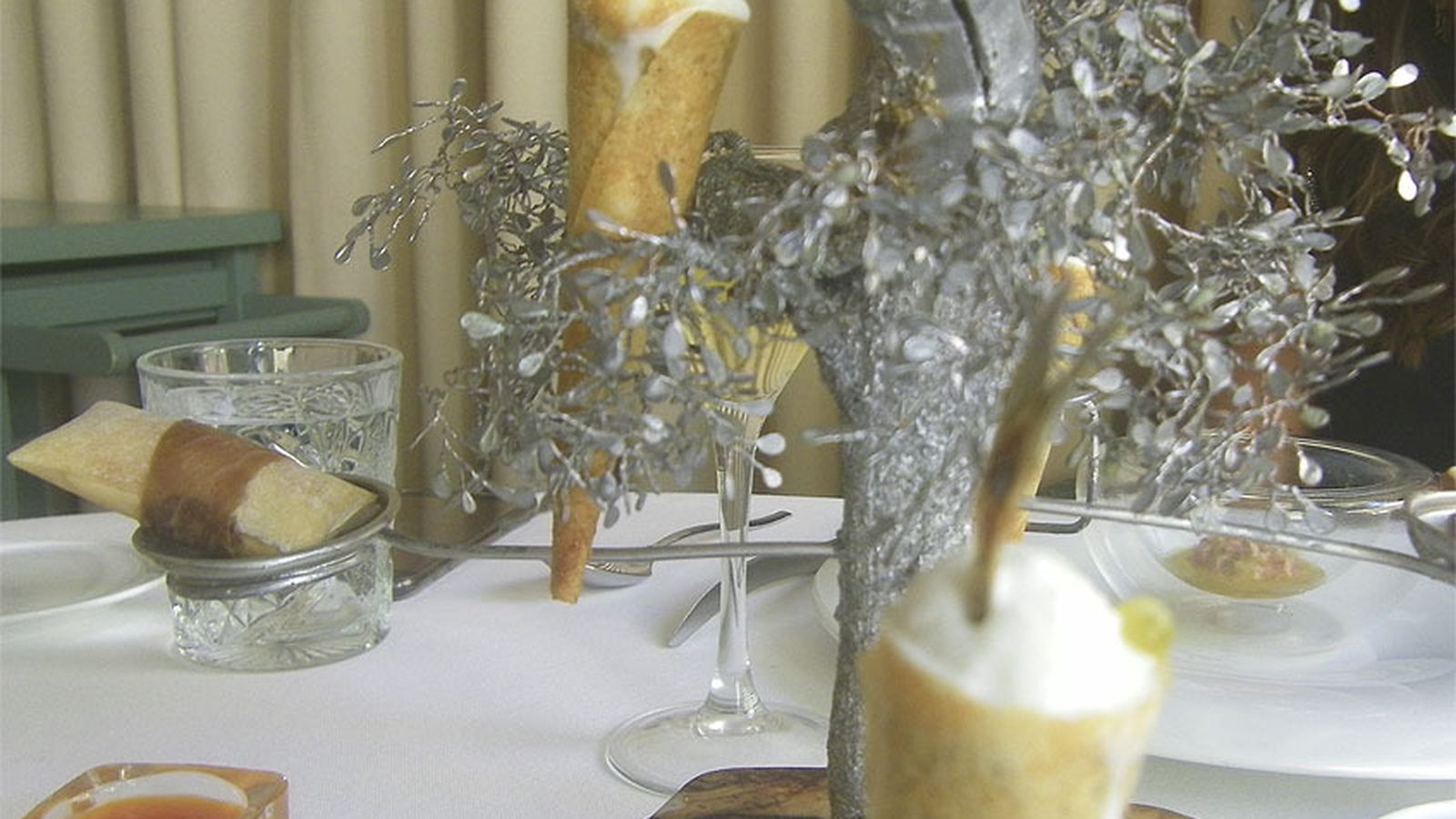 Algunas de las tapas como el barquillo de boquerón en vinagre o la regañá rellena se presentan en las ramas de un pequeño árbol.