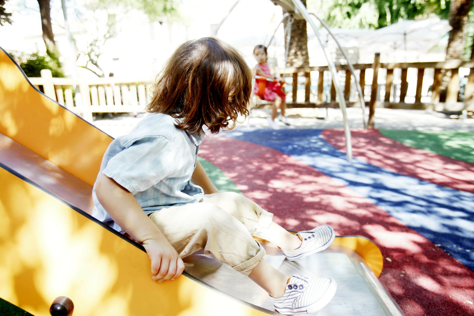 Dos pequeños juegan en un parque infantil.