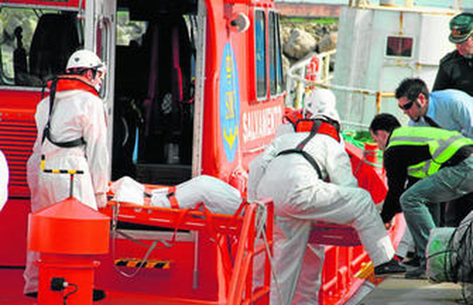 Efectivos de Salvamento Marítimo en el momento que trasladan a uno de los fallecidos.