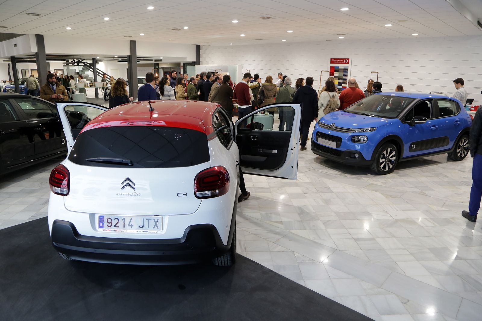 Varias personas en un concesionario.