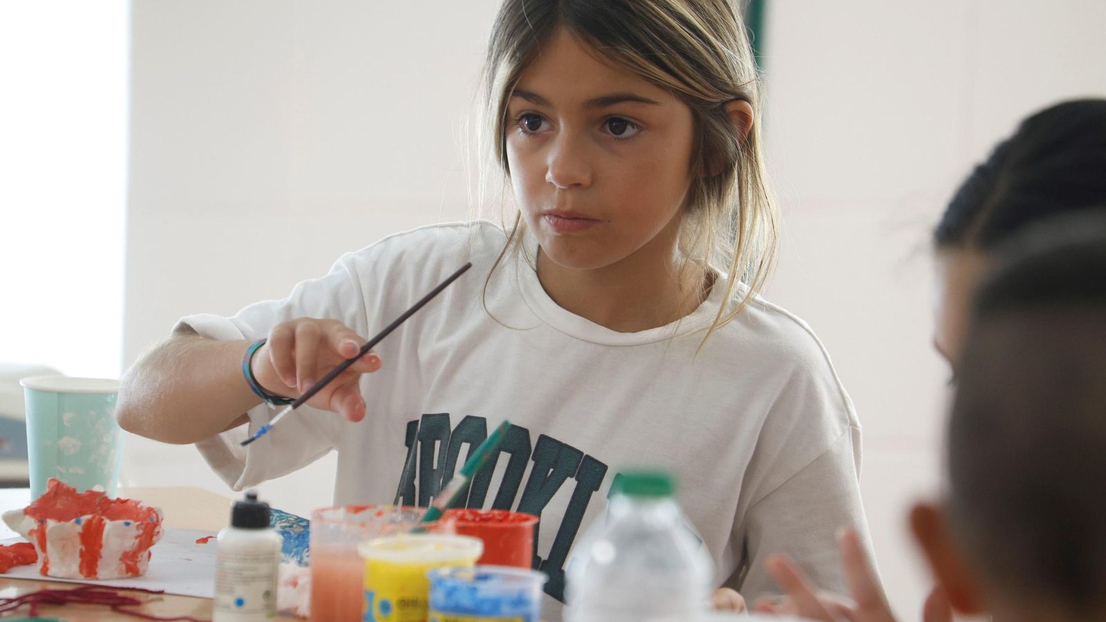 India, pintando una pieza de arcilla.