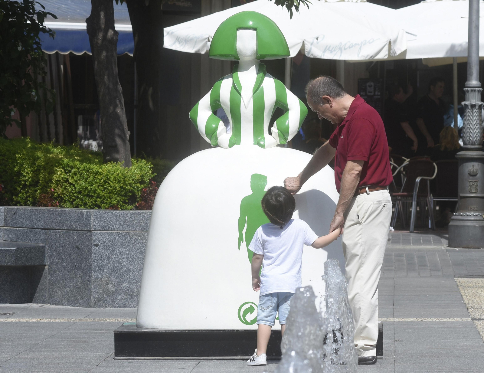 Un hombre muestra una de las meninas a un niño en las Tendillas.