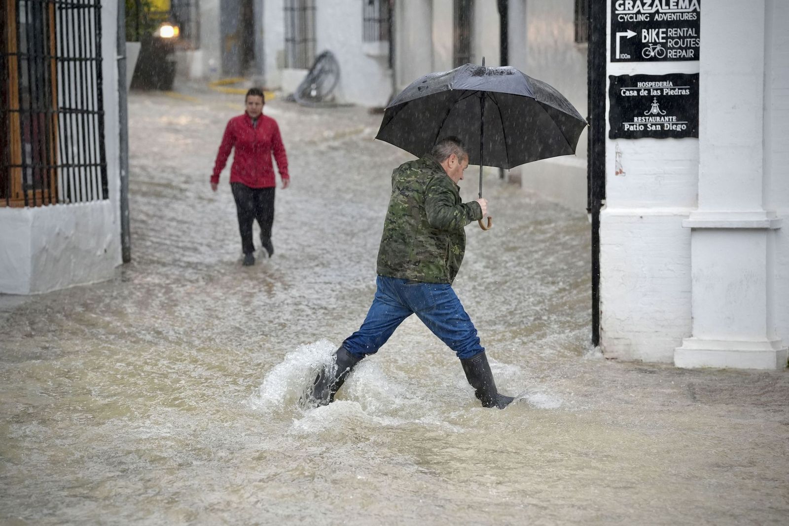 Un hombre cruza una calle inundada de Grazalema
