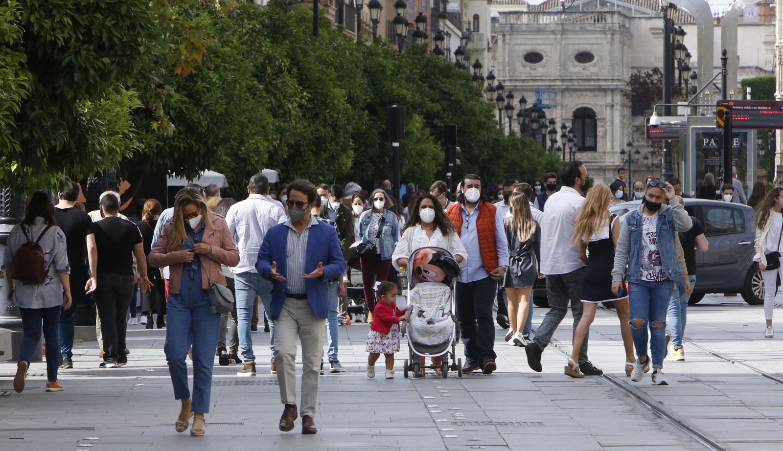 Varias personas caminan por la céntrica Avenida de la Constitución en una jornada festiva en la capital.