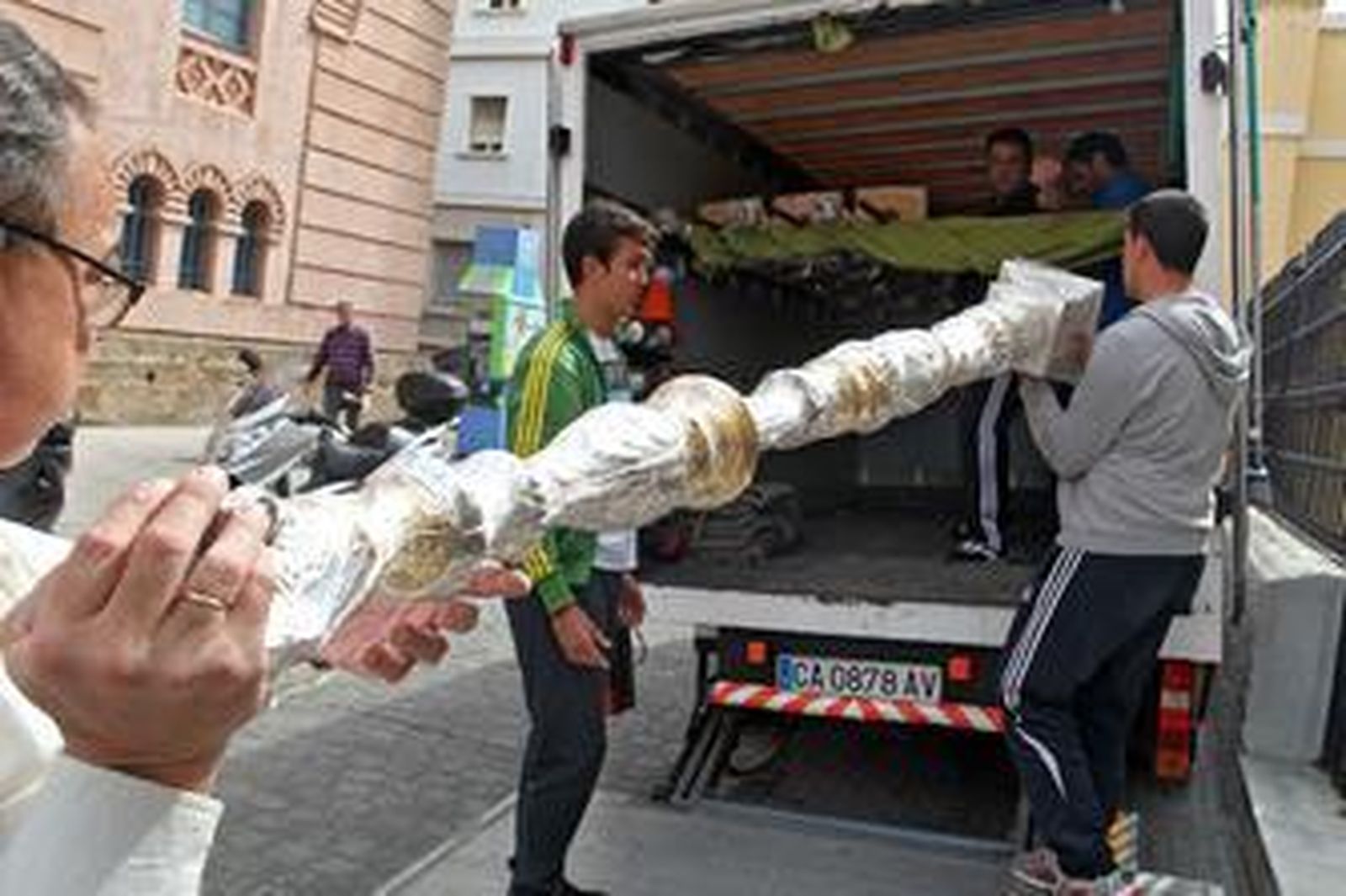 Varios cofrades de Expiración introducen un varal en una furgoneta ayer por la tarde, cuando empezó el desalojo de la casa de hermandad. /Jesús Marín