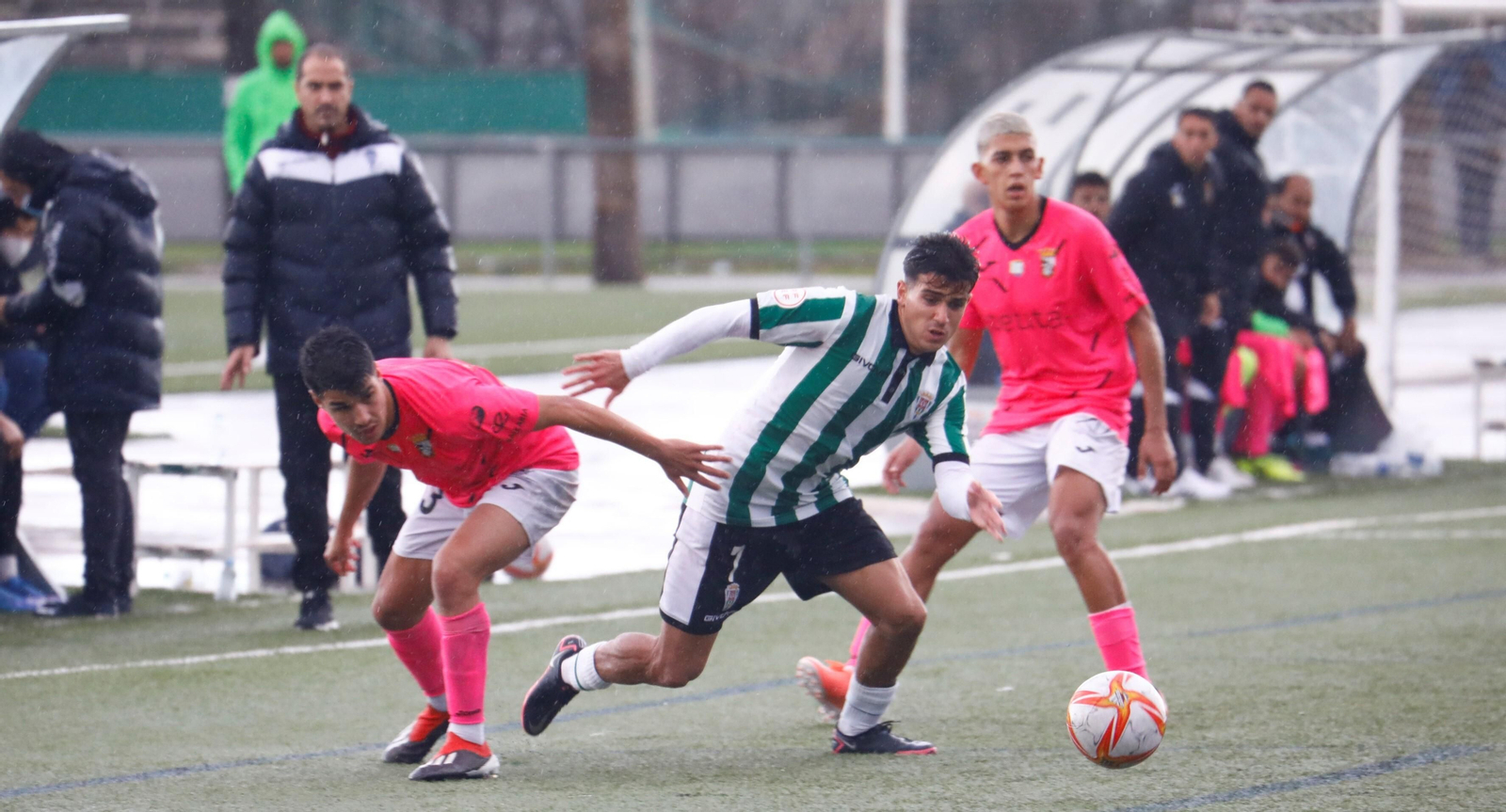 Juan Andrés, del Córdoba B, gana el balón entre dos jugadores del Ceuta B.