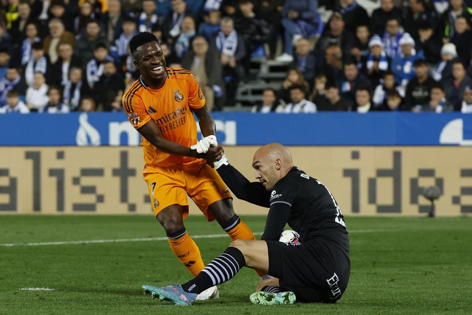 Vinícius ayuda a levantarse a Dmitrovic en el Leganés-Real Madrid.