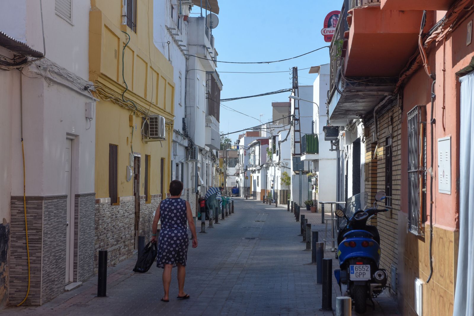 Una mujer camina por una calle de La Bachillera.