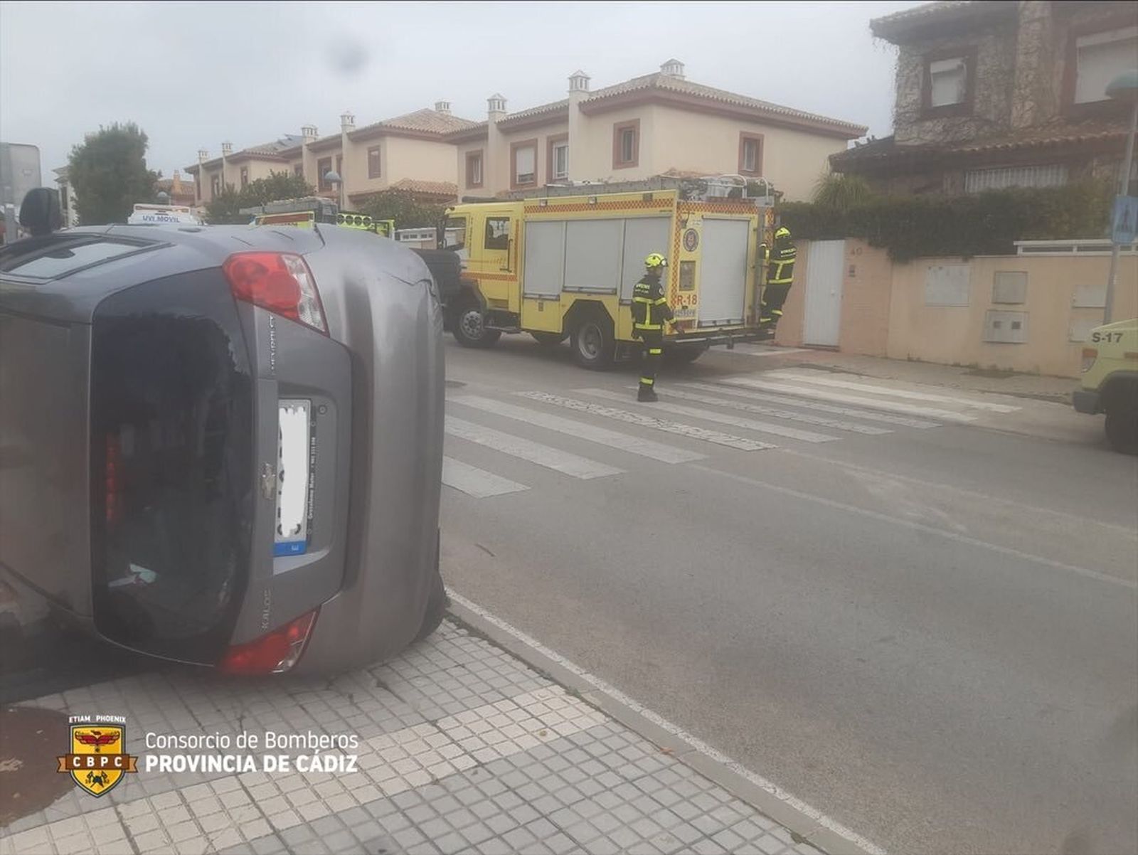 El coche volcado en la calle de El Puerto tras el choque.