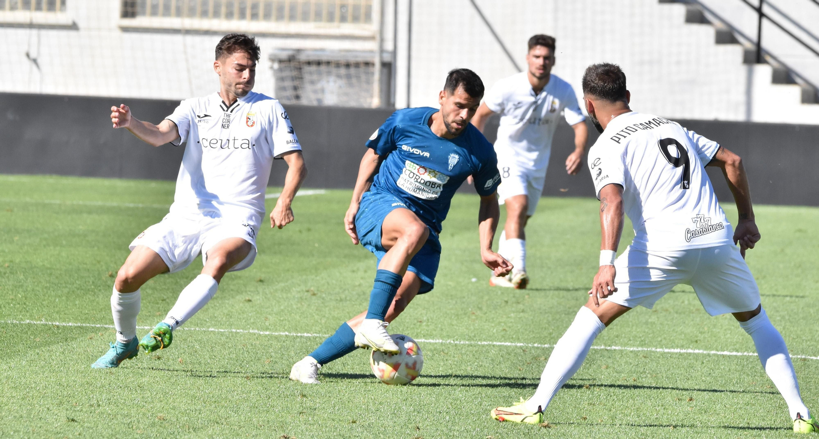 José Ruiz controla el balón entre dos jugadores del Ceuta en el partido de la primera vuelta.