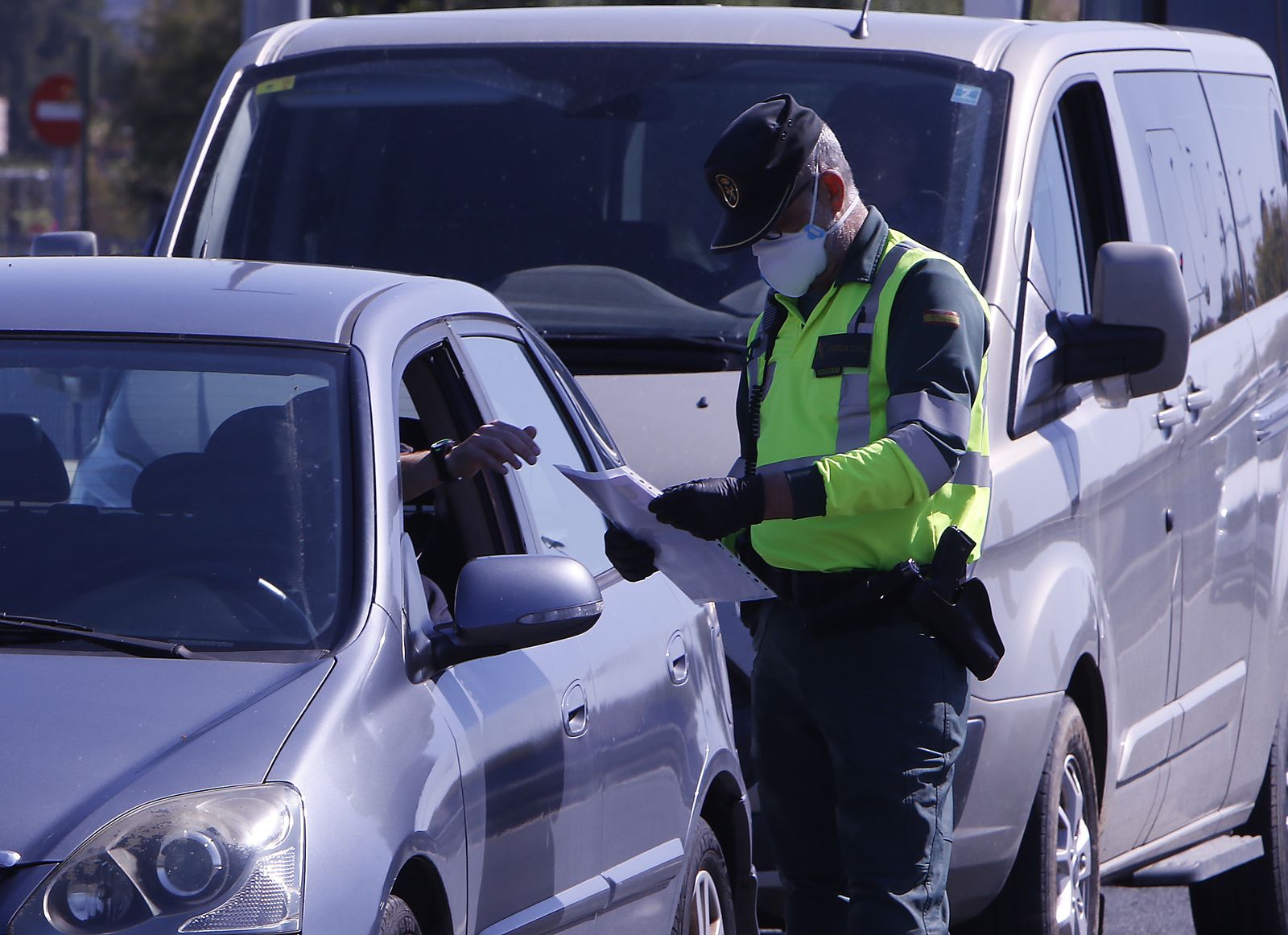 Un agente de la Guardia Civil, protegido con guantes y mascarilla, durante un control de tráfico.