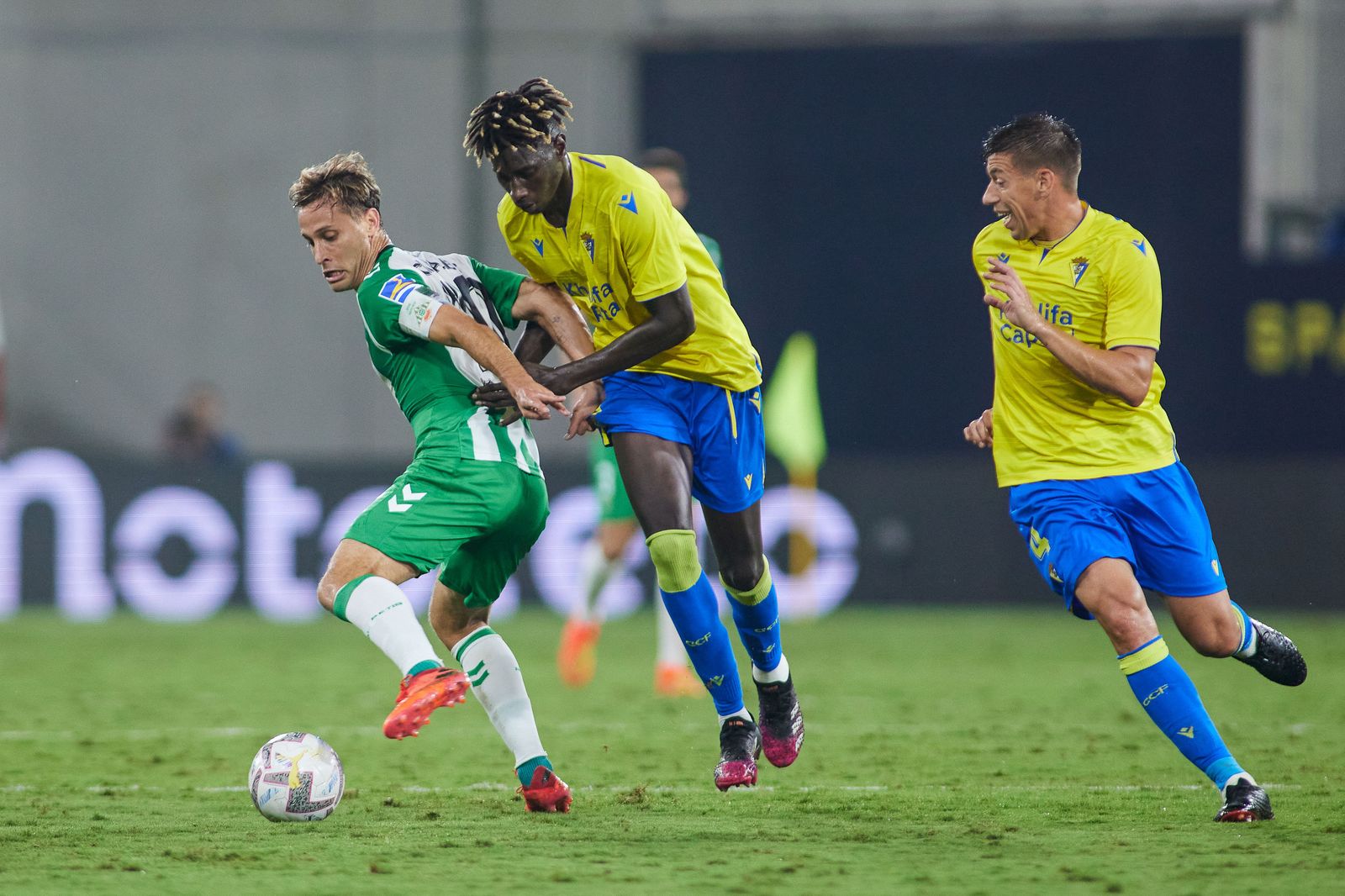 Canales disputa el balón ante dos jugadores de Cádiz.