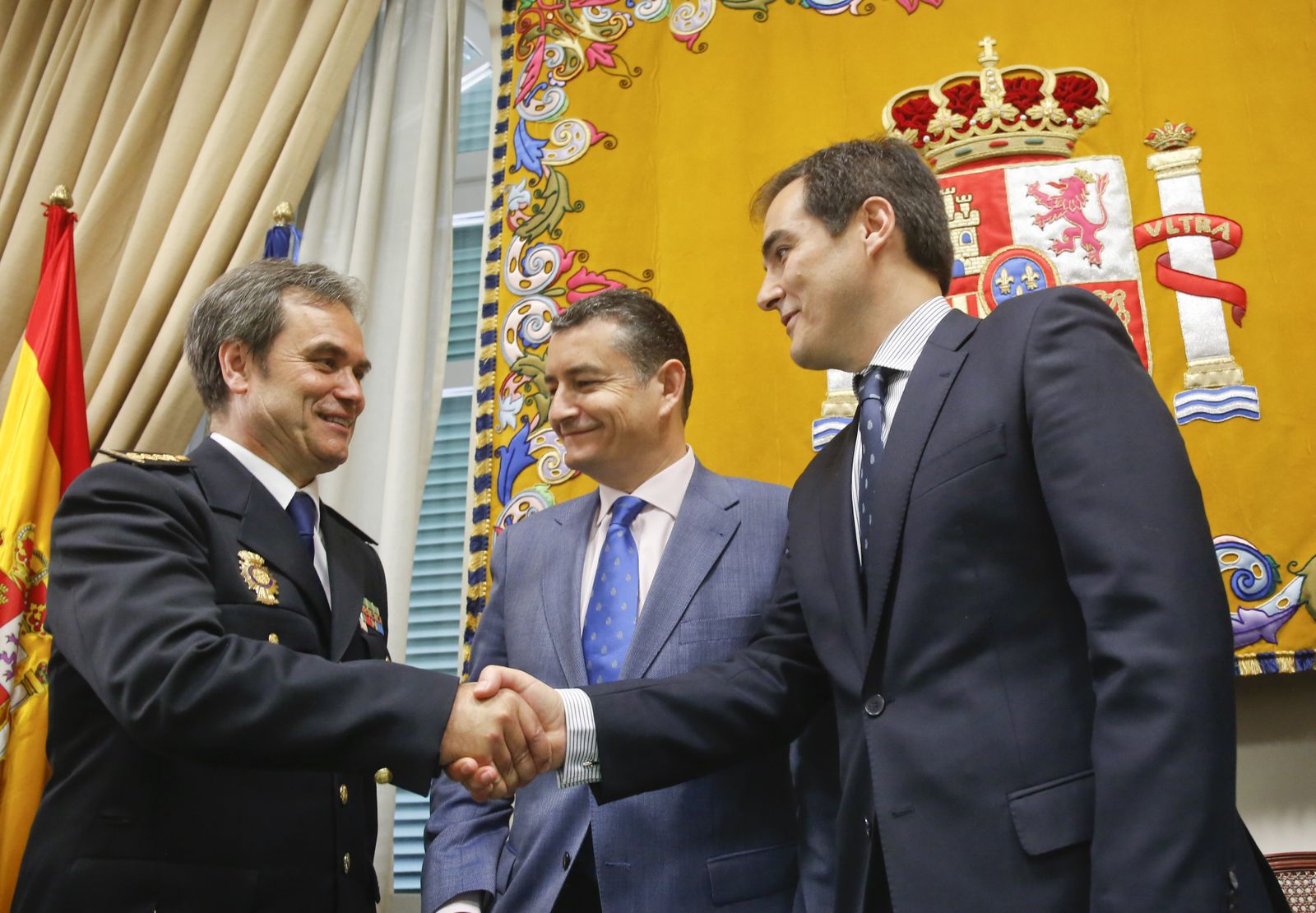 El nuevo comisario (izquierda) estrecha la mano del secretario de Estado de Seguridad, ante la mirada del delegado del Gobierno.