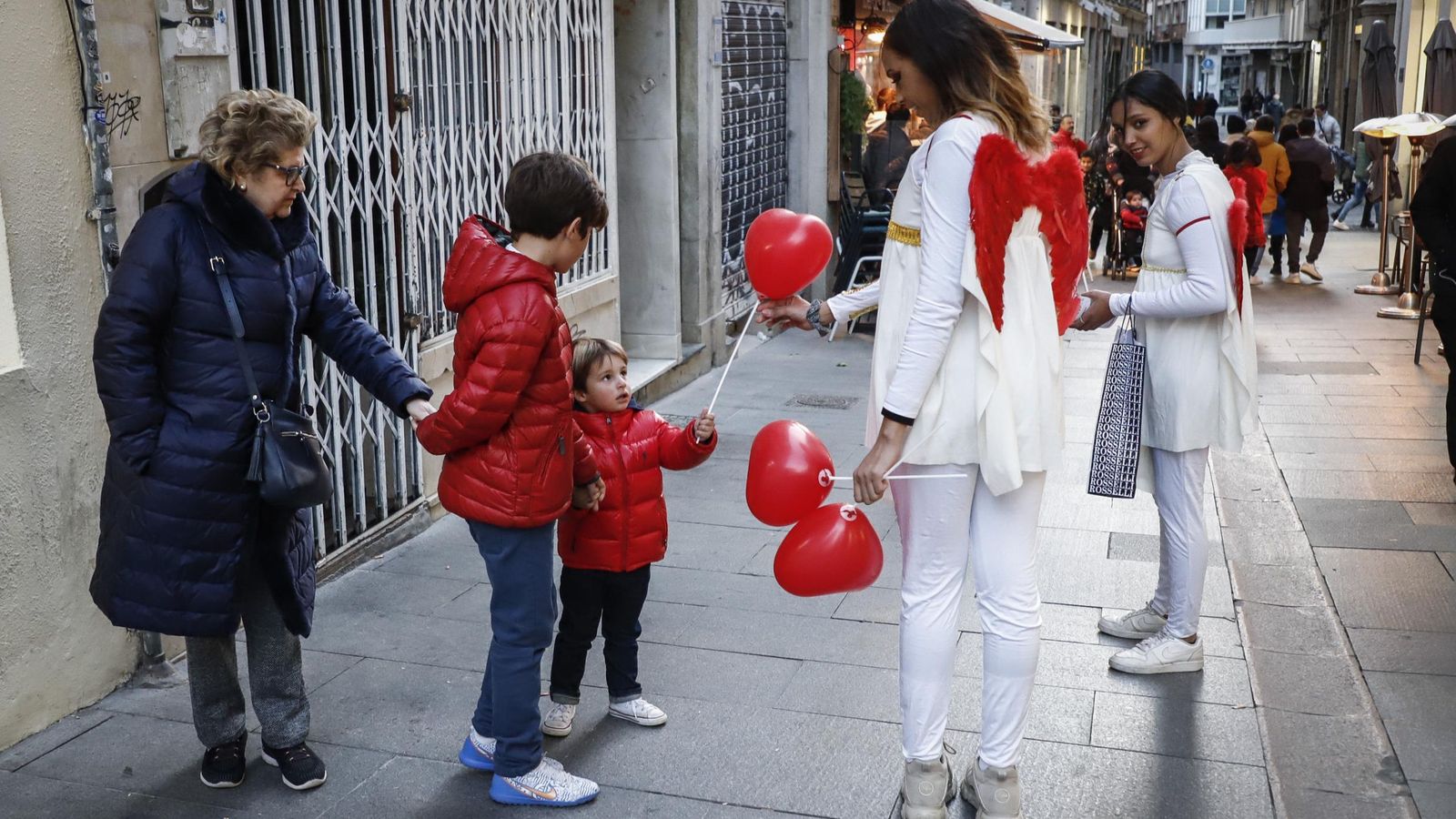 Niños recibiendo globos de parte de las modelos de Miguel Ángel Benavente.