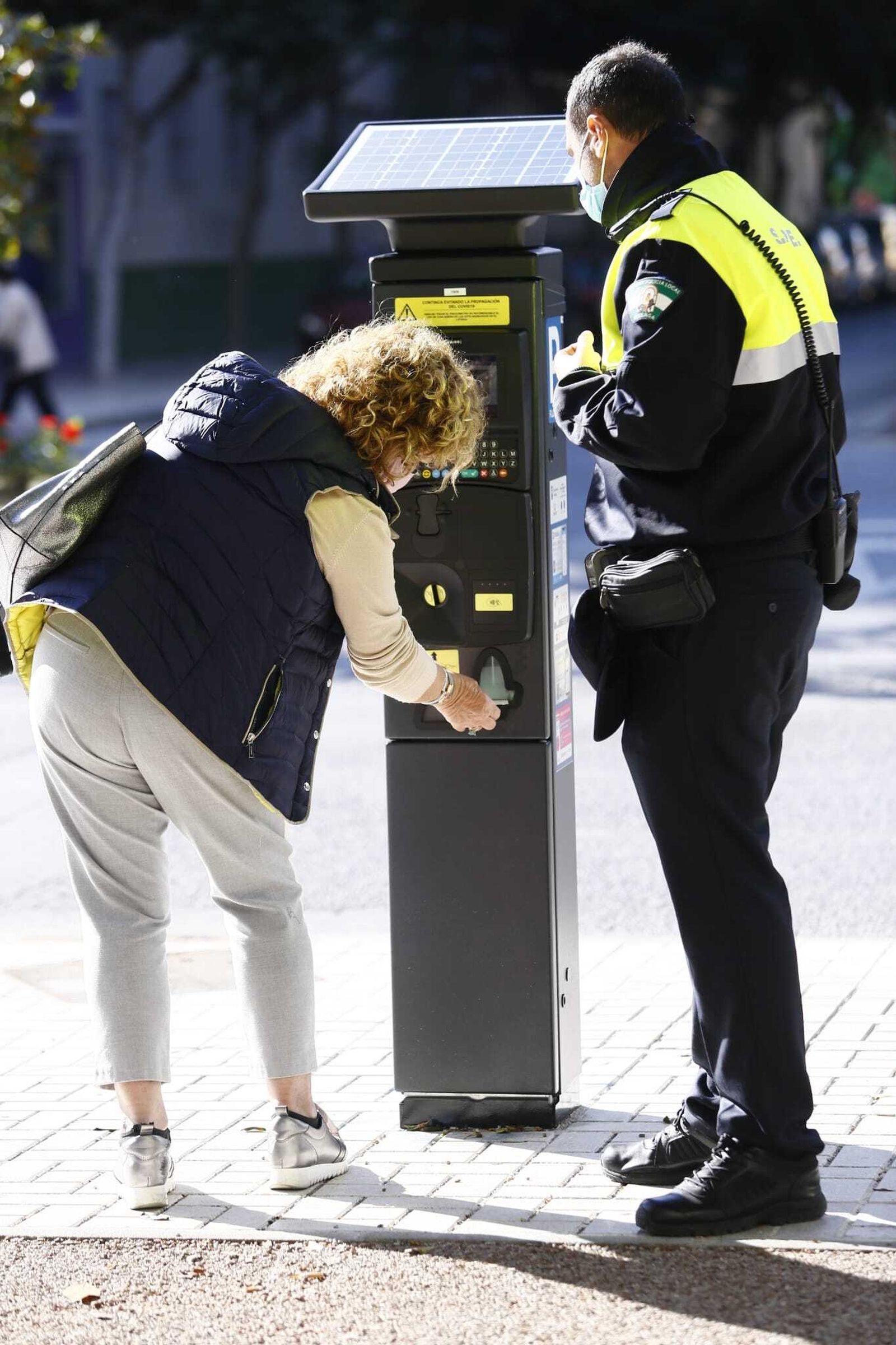 Un operario del SARE explica a una vecina el funcionamiento del parquímetro.