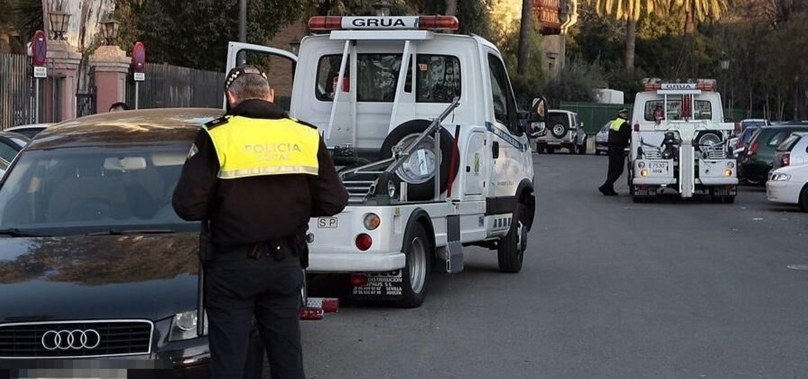 La grúa municipal retira un vehículo mal aparcado ante la presencia de la Policía Local, en una imagen de archivo.